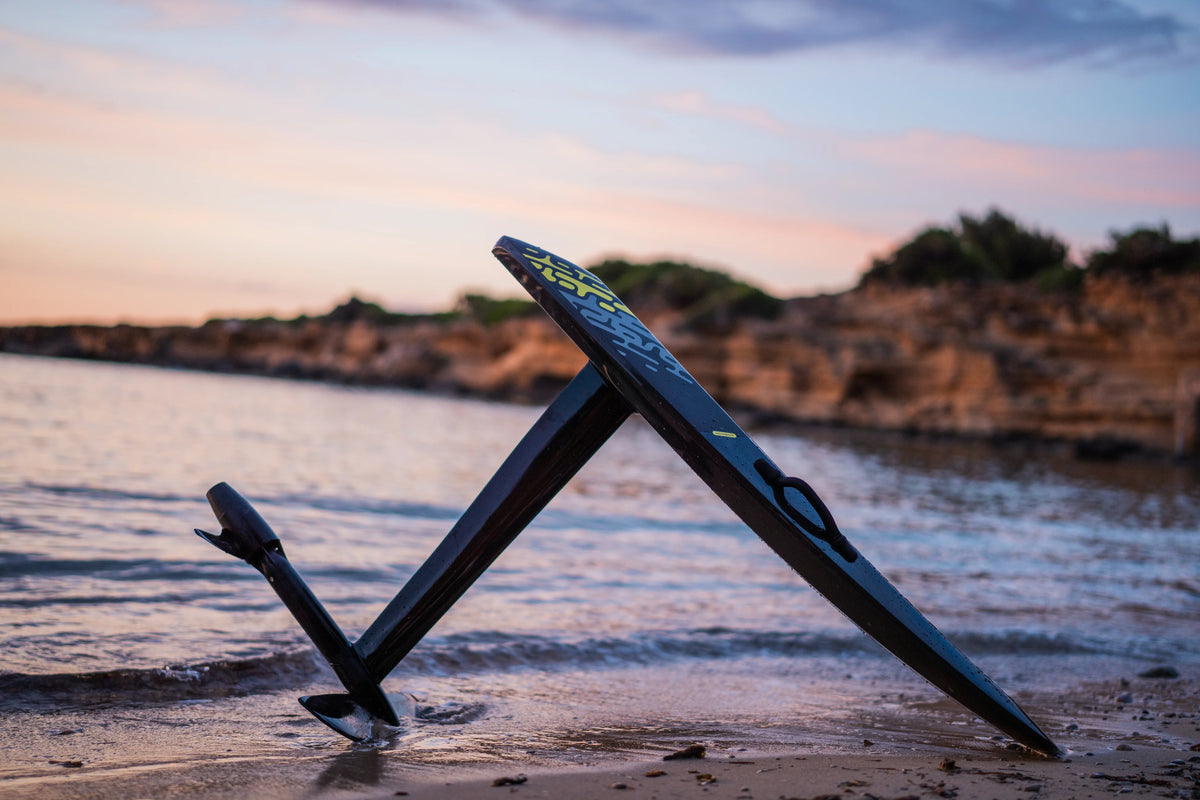Aerofoils Performance eFoil in Carbon Camo resting on a Mallorca beach at sunset, packed up after the day's last session