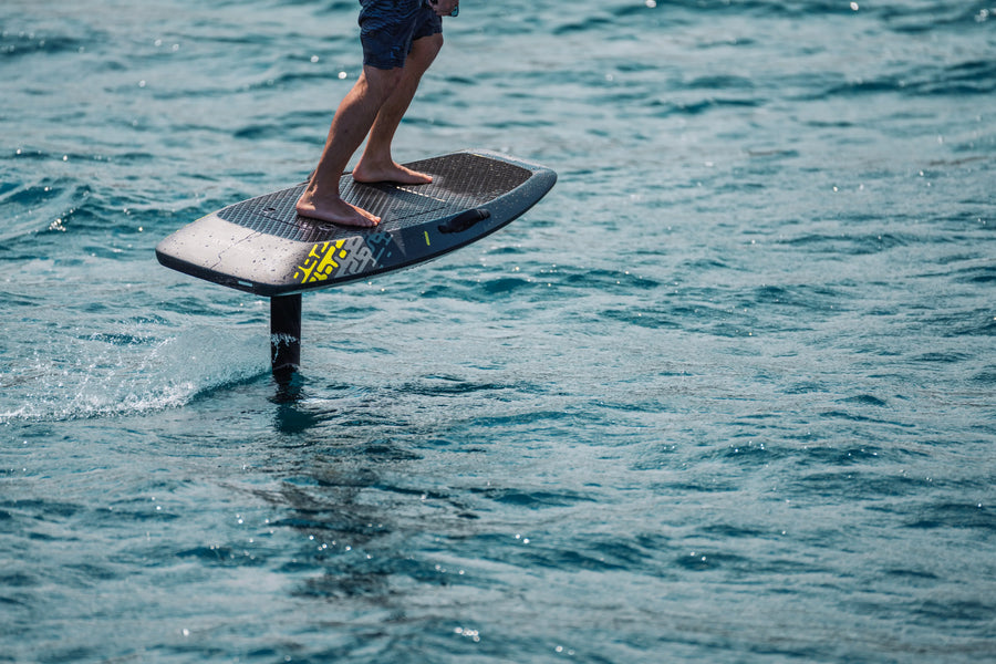 Close-up of an Aerofoils Performance eFoil board, mast, and fully shielded jet drive emerging from the water, no exposed propeller visible
